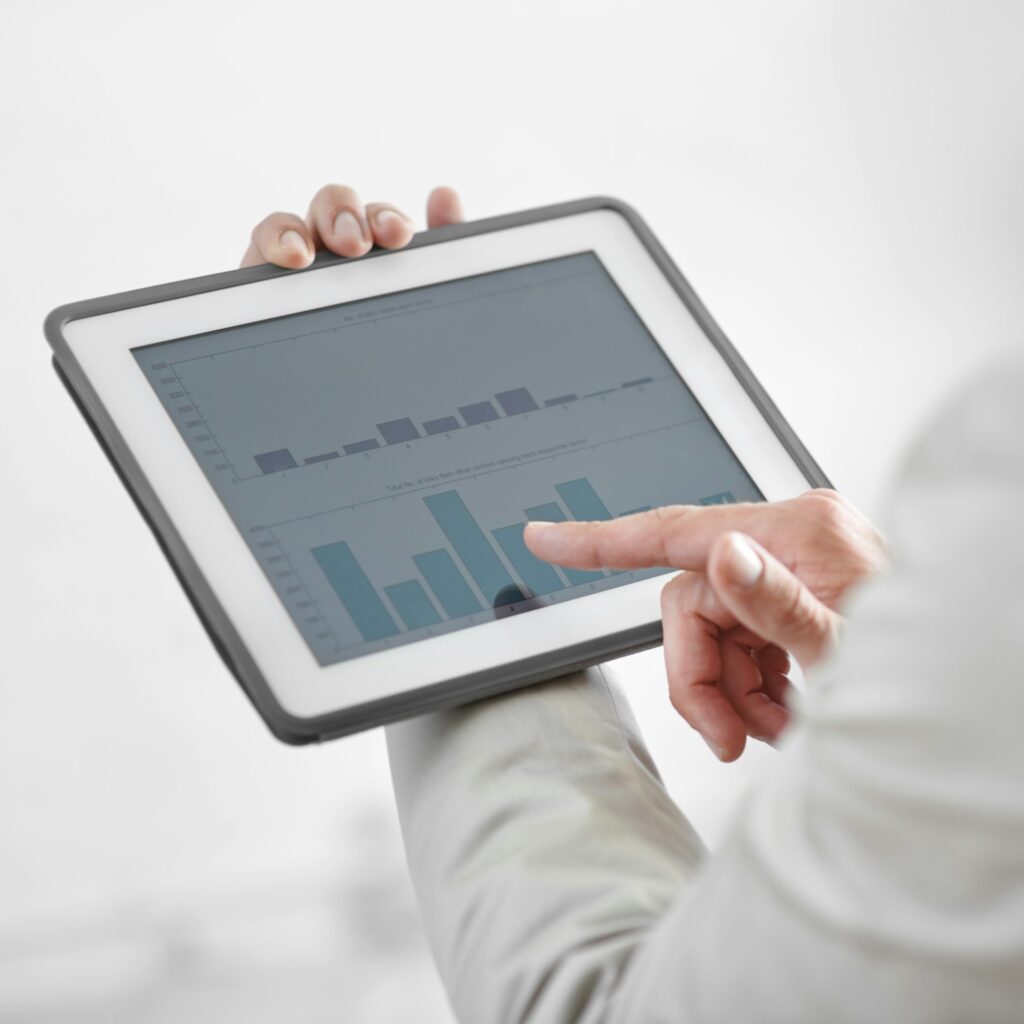 Cropped image of a businessman holding a digital tablet showing business data